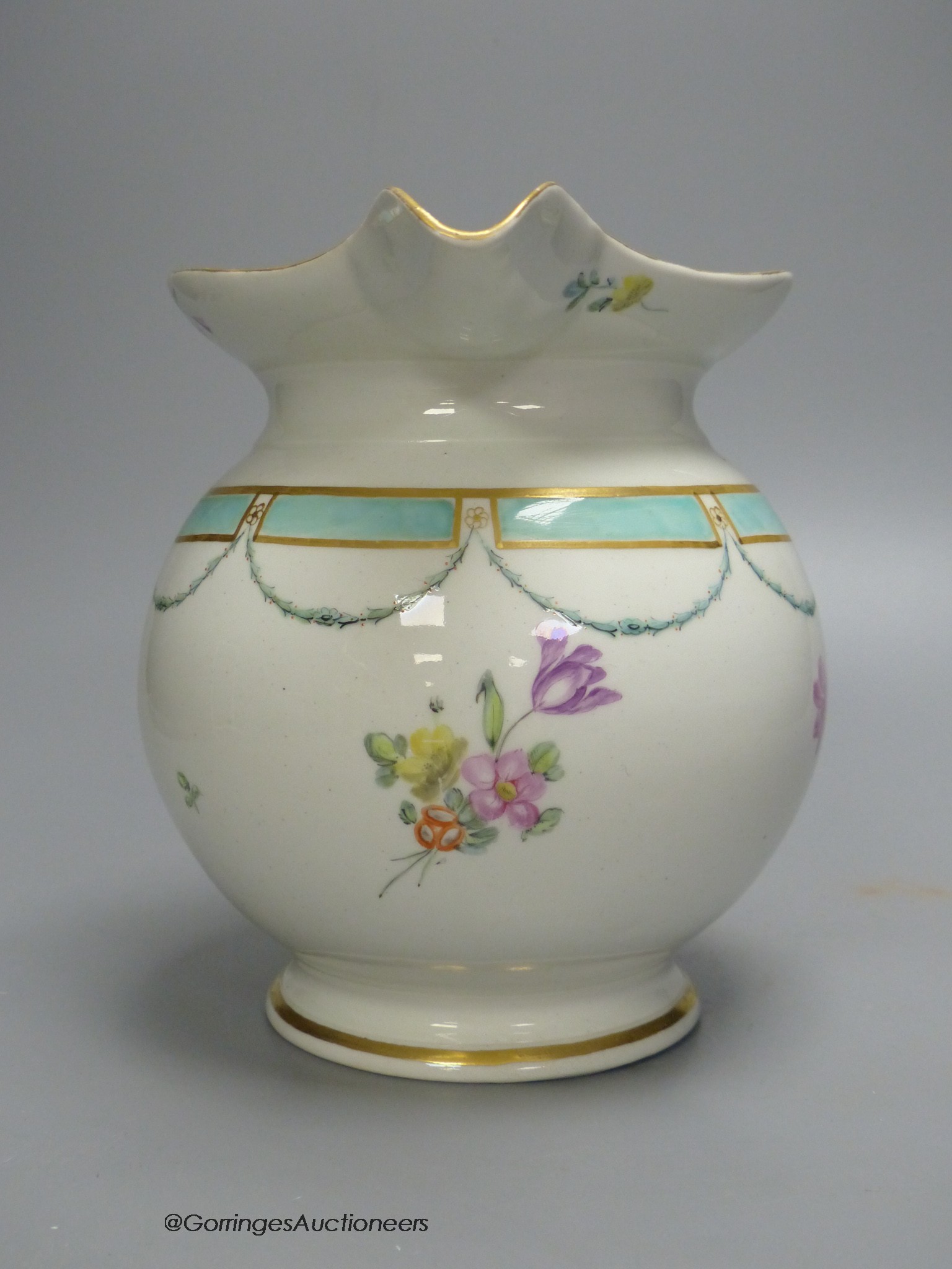 A Chelsea Derby jug of most unusual shape painted with flowers and a turquoise border, 18cm high